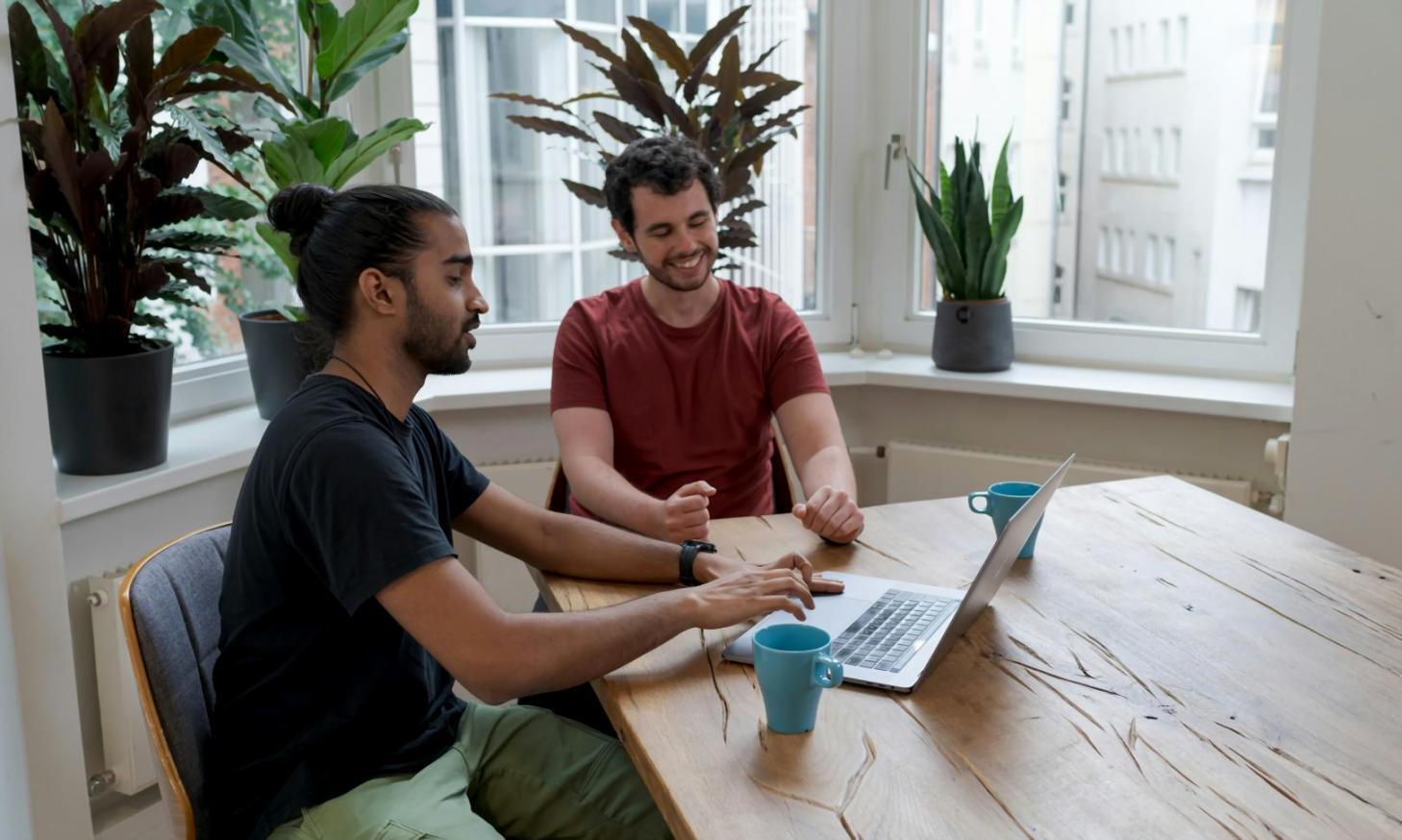 Australian family discussing financial planning documents together at kitchen table with laptop and paperwork